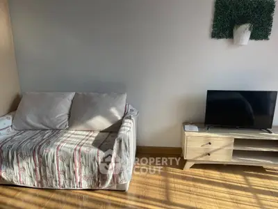 Cozy living room with sofa and TV stand, perfect for relaxation.