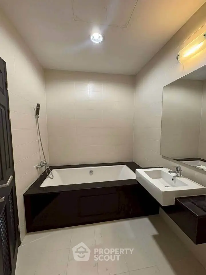 Modern bathroom with sleek bathtub and stylish sink in contemporary apartment.