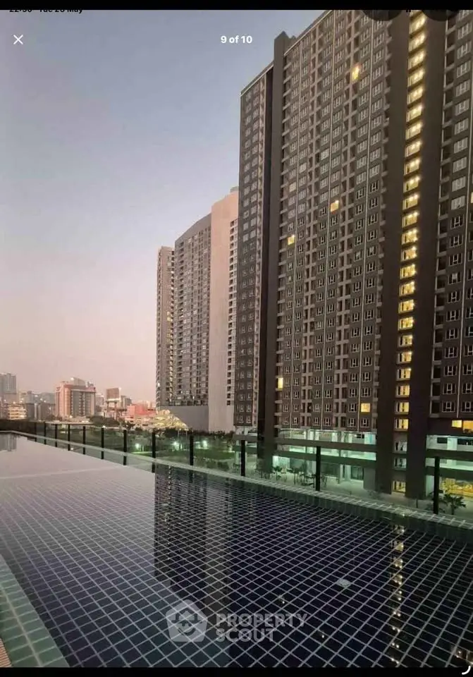 Stunning high-rise building with rooftop pool offering breathtaking city views at sunset.