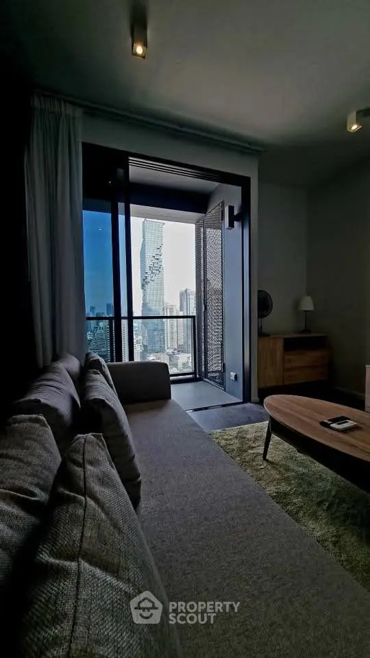 Modern living room with stunning city view from balcony, featuring stylish furniture and cozy ambiance.