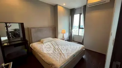 Cozy bedroom with city view, featuring a comfortable bed and modern decor.