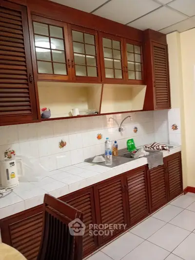 Charming kitchen with wooden cabinets and tiled backsplash, featuring a cozy and functional design.