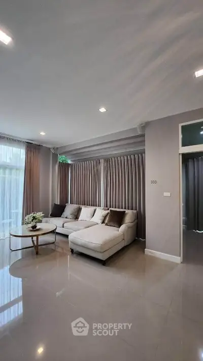 Spacious modern living room with elegant sofa and large windows for natural light.