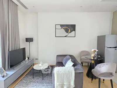 Modern living room with sleek furniture and stylish decor, featuring a cozy seating area and contemporary artwork.