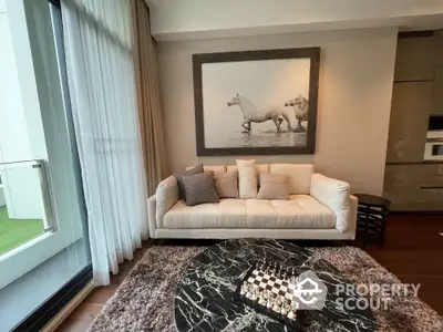 Elegant living room with plush sofa, large artwork, and chess set on marble table.