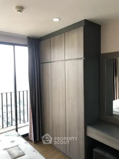 Modern bedroom with large wardrobe and balcony view in high-rise apartment