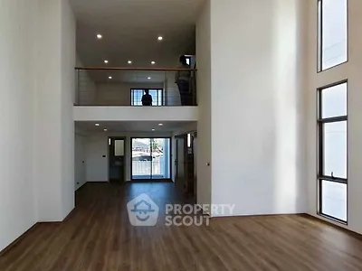 Spacious modern living room with high ceilings and large windows in a contemporary home.