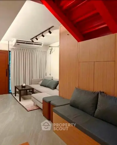 Modern living room with stylish furniture and unique red staircase accent