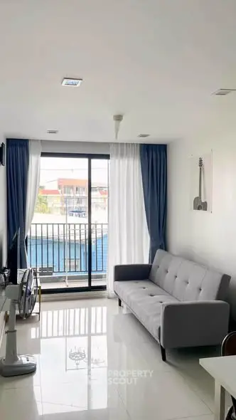 Modern living room with sleek sofa and large window offering city view