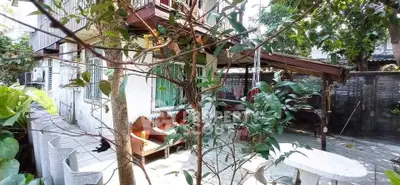 Charming residential property with lush garden and outdoor seating area, perfect for relaxation and entertaining.