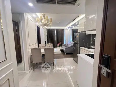 Luxurious open-layout kitchen and dining area with elegant chandelier and modern appliances.