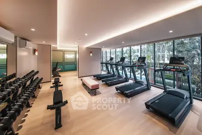 Modern gym with state-of-the-art equipment and large windows offering a scenic view.