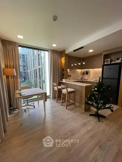 Modern open-layout kitchen and living area with large windows and stylish decor.