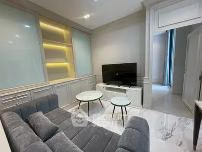 Modern living room with sleek design, featuring a plush gray sofa, marble flooring, and built-in illuminated shelves.