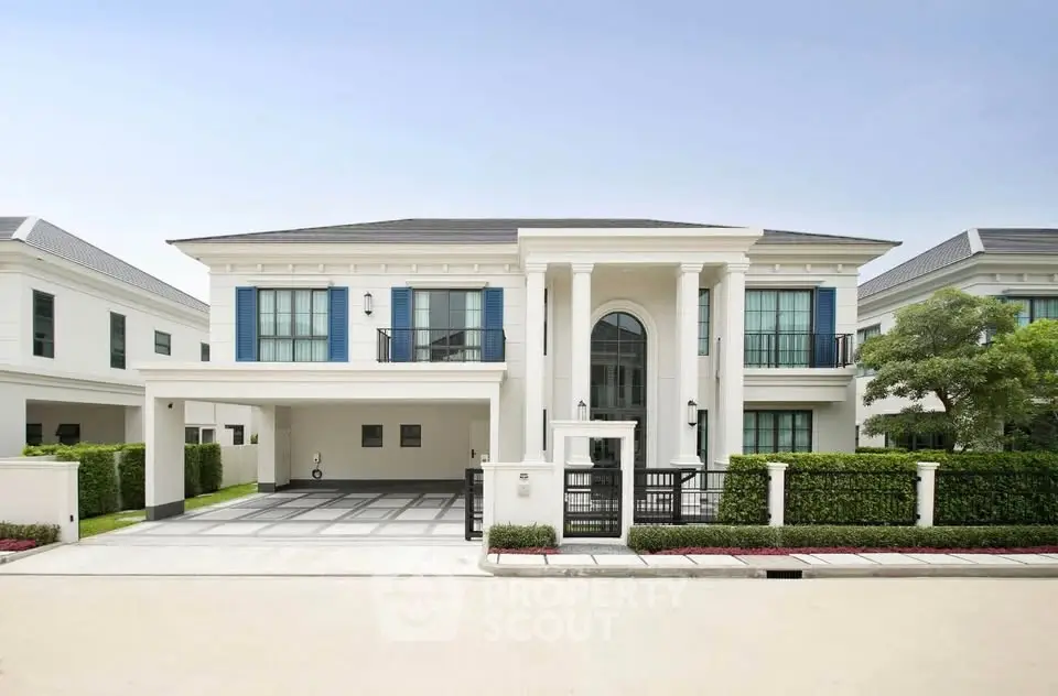 Luxurious modern villa with grand entrance and spacious driveway in upscale neighborhood.