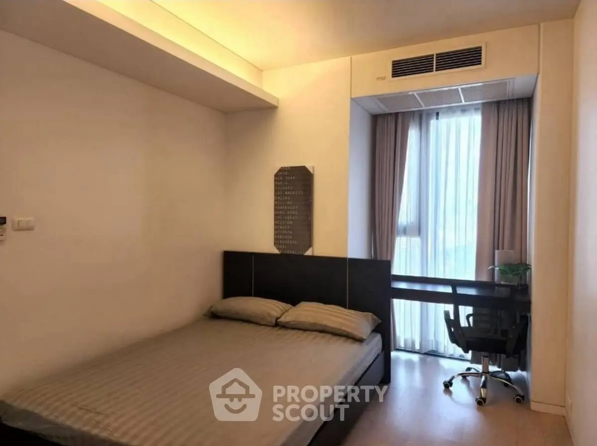 Modern bedroom with cozy bed and study desk near window