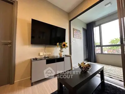 Modern living room with wall-mounted TV and stylish decor in a cozy apartment.