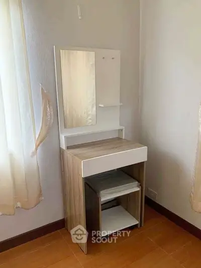 Cozy bedroom corner with modern wooden vanity and mirror