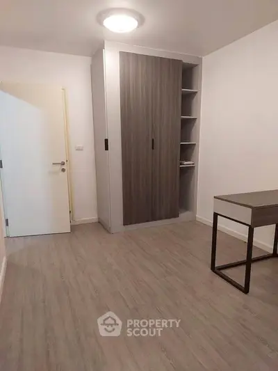 Modern minimalist bedroom with sleek wardrobe and desk, perfect for a stylish urban lifestyle.