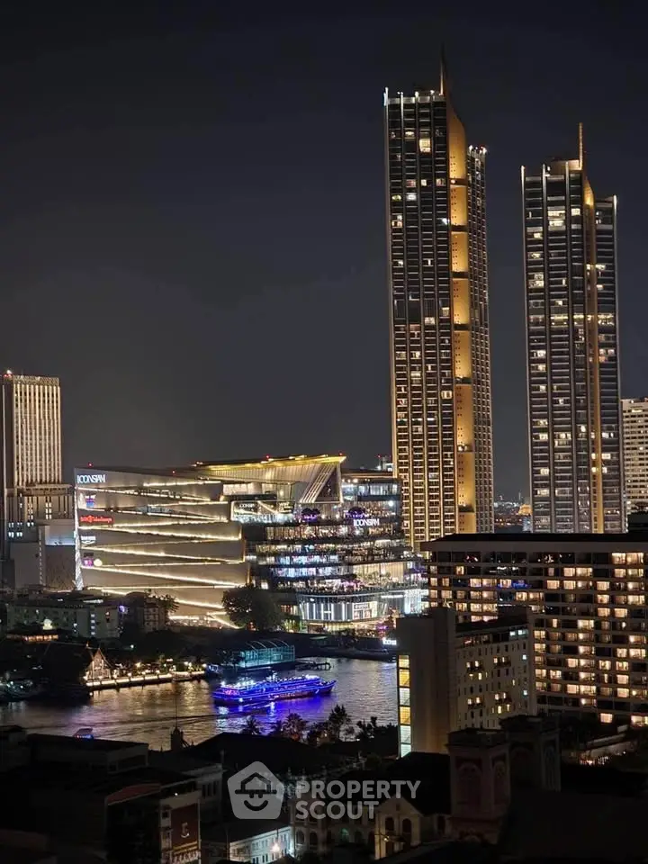 Stunning night view of modern skyscrapers and illuminated riverfront in a vibrant cityscape.