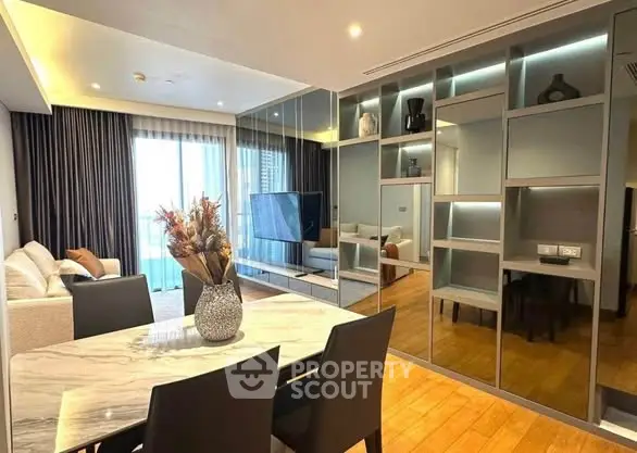 Modern living room with elegant decor and open layout, featuring a stylish dining area and large windows.