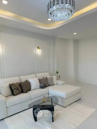 Elegant living room with modern chandelier and stylish white sofa