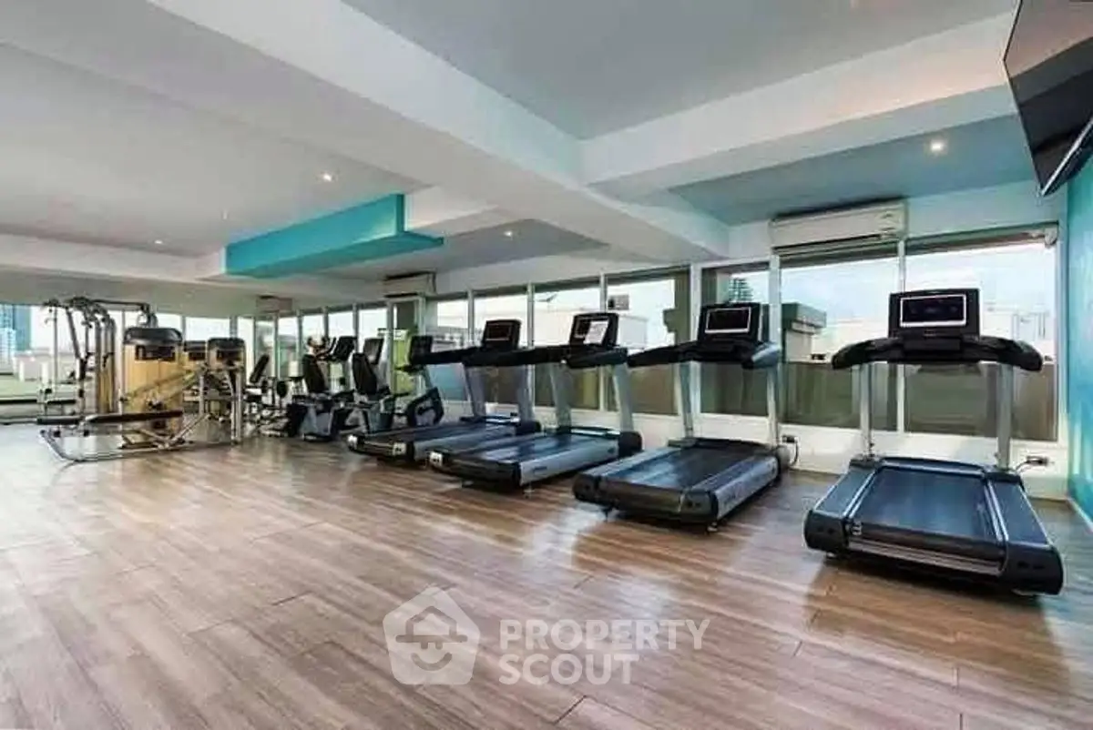 Spacious modern gym with treadmills and exercise equipment in a luxury building.