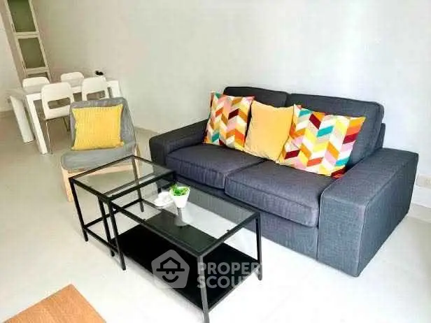 Modern living room with colorful cushions and sleek glass coffee table