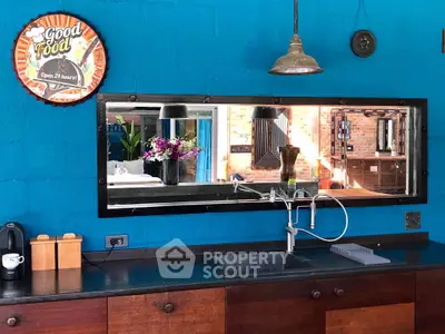 Charming kitchen with vibrant blue walls, rustic wooden cabinets, and modern fixtures, perfect for culinary enthusiasts.