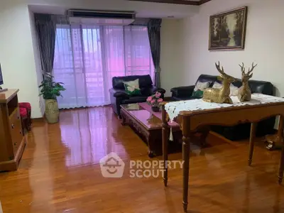 Spacious living room with elegant decor and large windows offering natural light.
