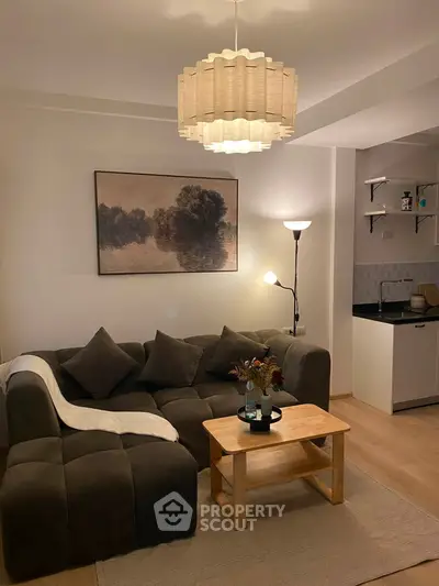 Cozy living room with modern decor and open kitchen layout, perfect for relaxation and entertaining.