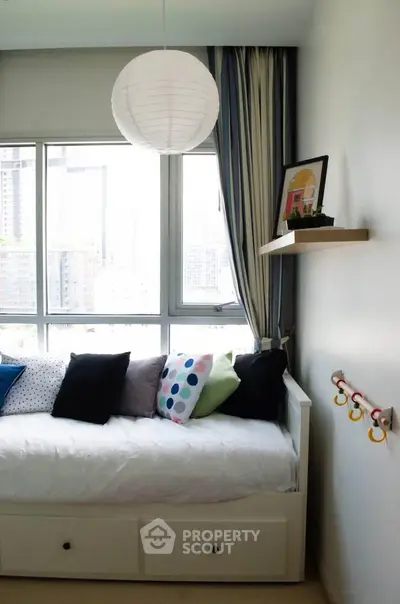 Charming bedroom with city view, featuring a cozy daybed and modern decor, perfect for urban living.