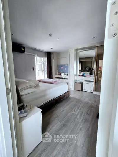 Spacious modern bedroom with stylish decor and ample natural light