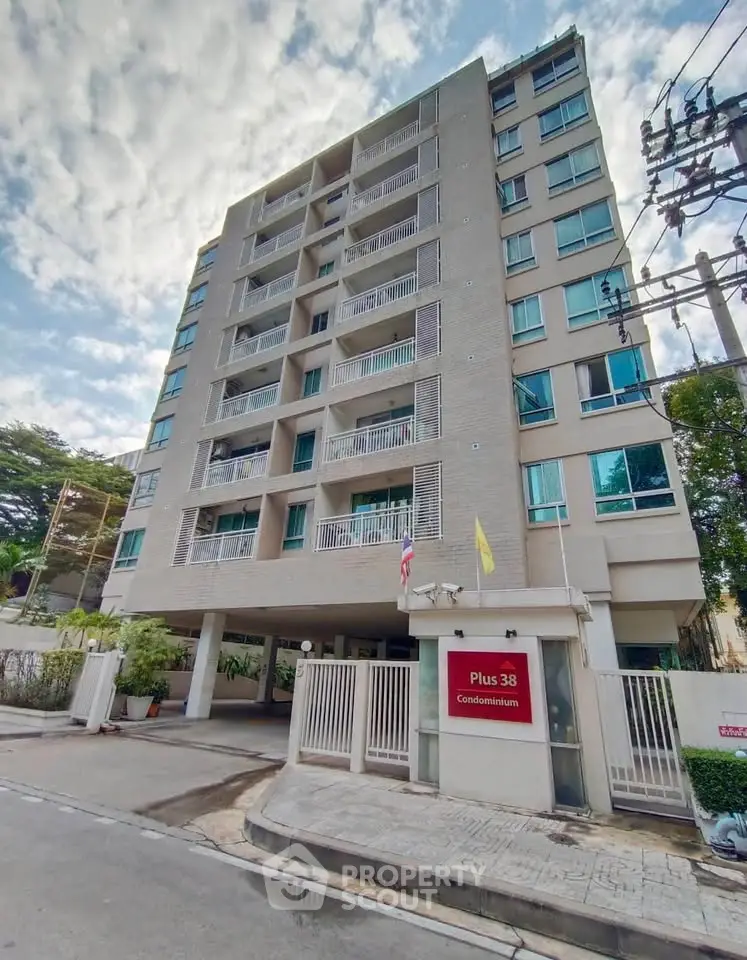 Modern condominium building with multiple floors and balconies in urban setting.