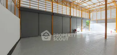 Spacious industrial warehouse with high ceilings and large roller doors