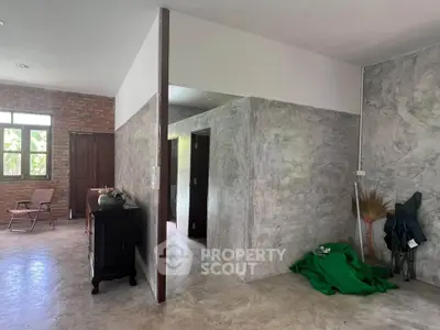 Spacious industrial-style interior with exposed brick and concrete walls, featuring modern minimalist decor.
