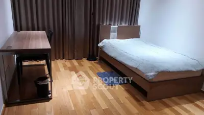 Modern bedroom with wooden flooring and minimalist furniture