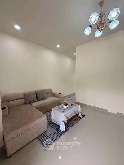 Modern living room with elegant chandelier and cozy sofa set