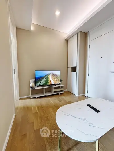 Modern living room with wooden flooring and sleek TV setup