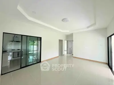 Spacious modern living room with open kitchen and sleek tile flooring