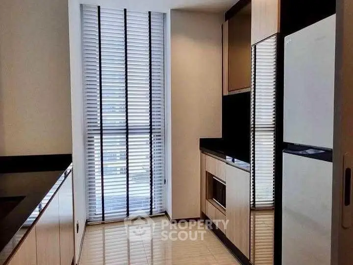 Modern kitchen with sleek cabinetry and large window for natural light.