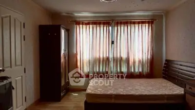 Cozy bedroom with wooden furniture and soft lighting, perfect for relaxation.