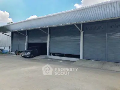 Spacious industrial warehouse with large roller doors and ample parking space.