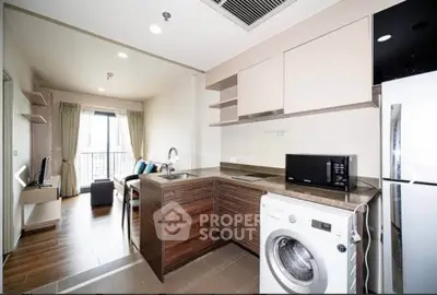 Modern open-layout kitchen with washing machine and sleek appliances in a stylish apartment.