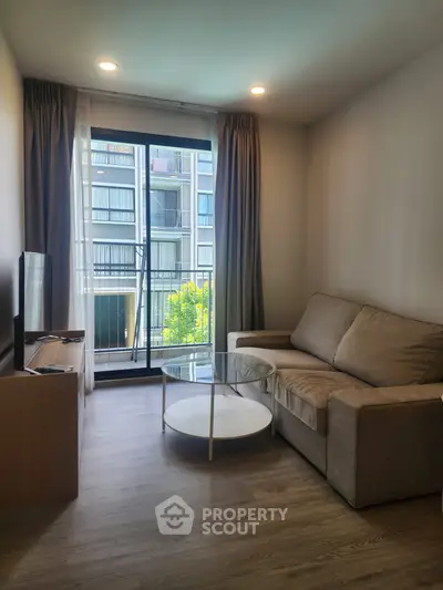 Modern living room with cozy sofa and large window offering a view of the cityscape.