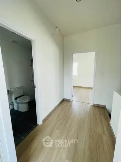 Spacious hallway with wooden flooring and modern bathroom access