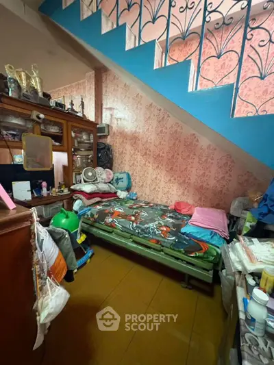 Cozy under-stair bedroom with unique storage solutions and vibrant decor