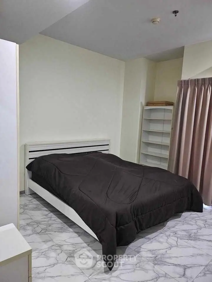 Modern bedroom with sleek design and marble flooring, featuring a cozy bed and ample natural light.