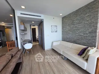 Modern living room with stylish decor and open layout, featuring a cozy sofa and elegant wooden flooring.