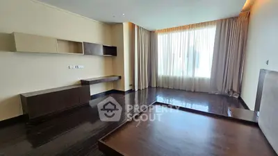 Spacious modern living room with elegant wooden flooring and large window.